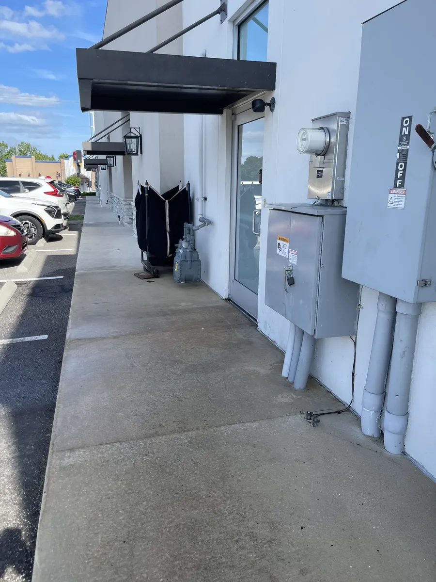 Clean side walkway and building exterior after commercial pressure washing service