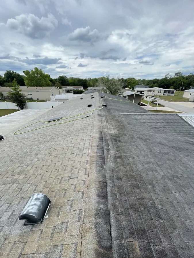 Mobile home shingle roof mid-soft-wash — before and after split visible on ridge line, Polk County FL