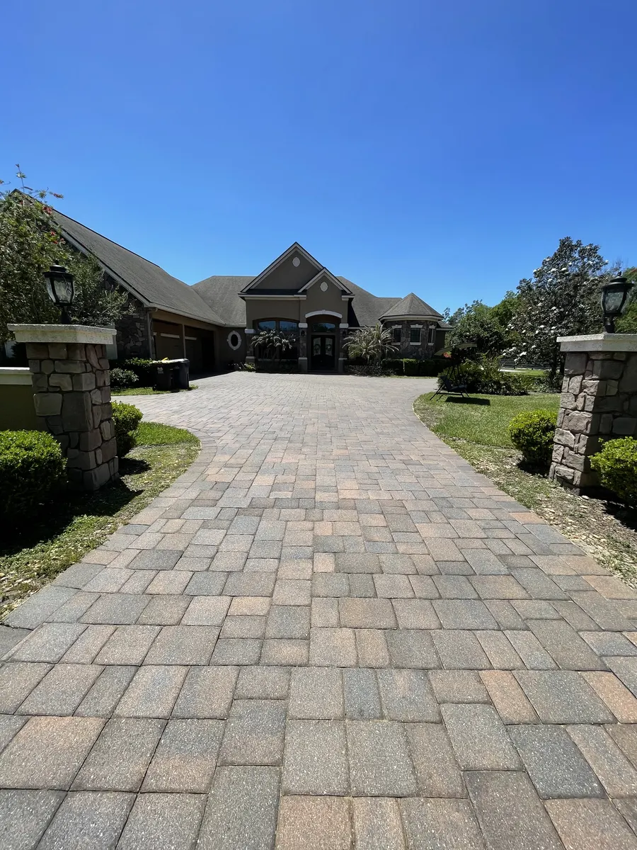 Luxury estate paver driveway after clean, sand & seal — stone pillar entrance, Polk County FL