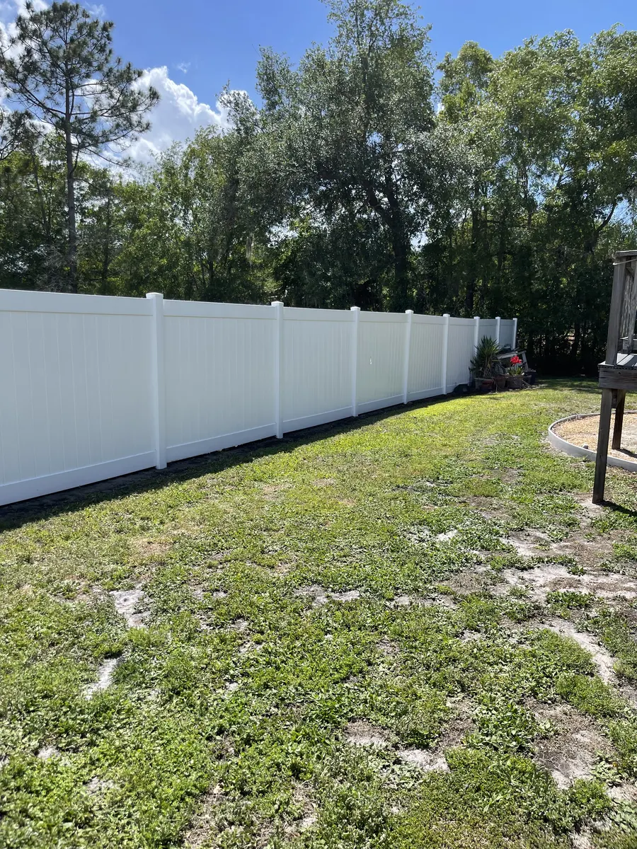 Full-length vinyl fence after professional soft washing — gleaming white result