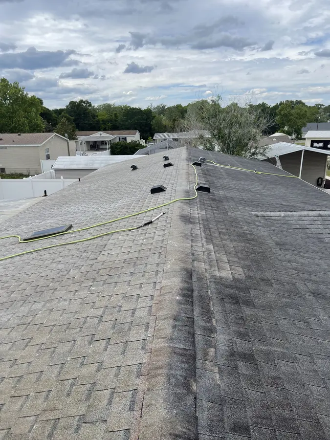 Roof during soft wash treatment — clean line contrast visible across shingles